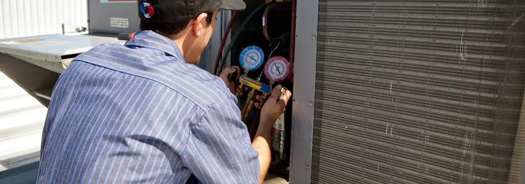 HVAC technician servicing a condenser unit in Campbell